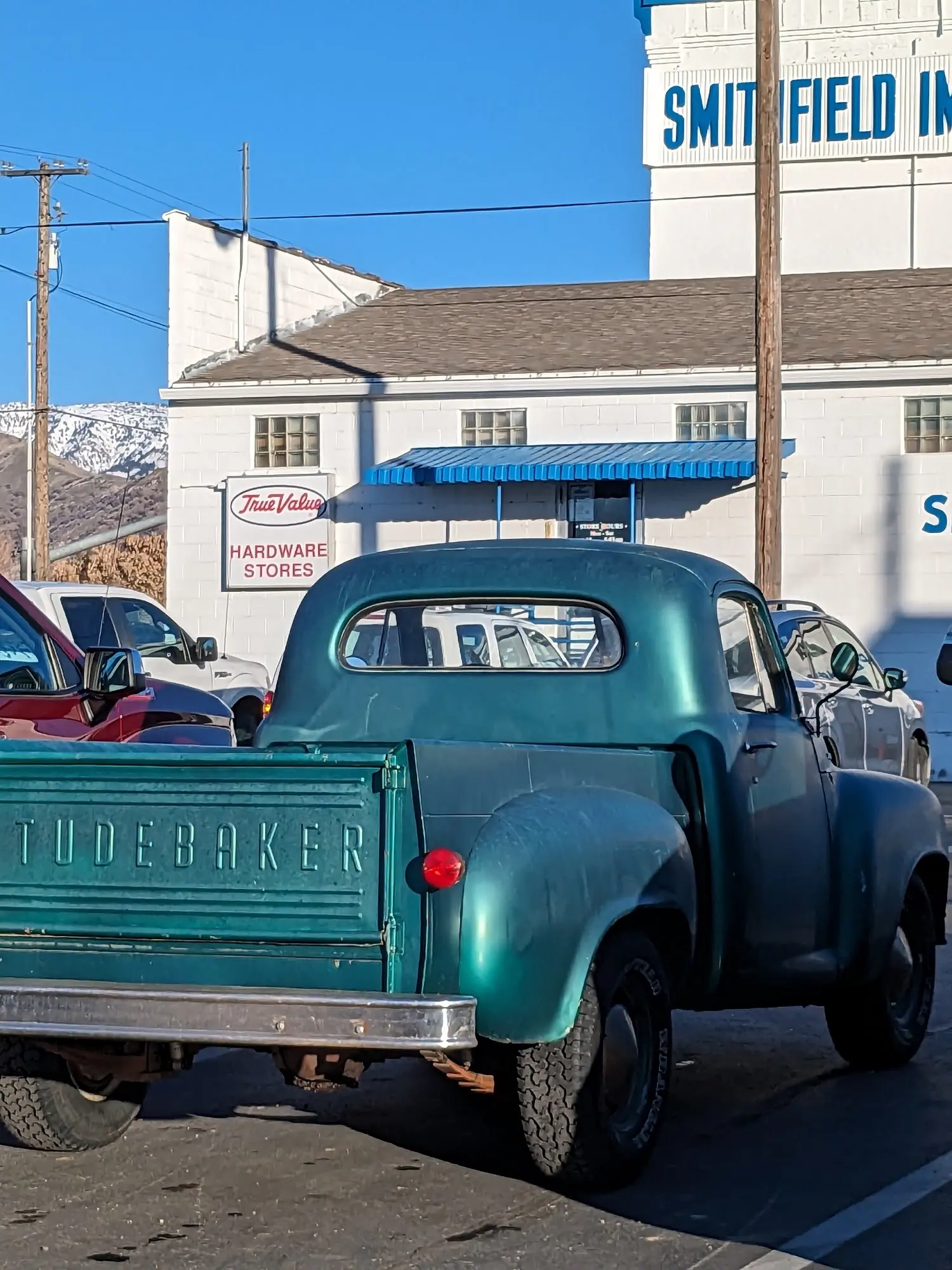 Vintage green pickup tailgate beside the building